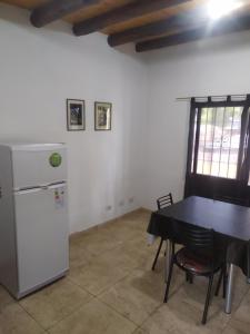 a kitchen with a table and a refrigerator in a room at Departamentos Anchorena #5 in Ciudad Lujan de Cuyo
