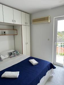 歐克魯東吉的住宿－Seaside apartments with a swimming pool Okrug Donji, Ciovo - 5244，一间卧室配有一张带蓝色床单的床和一扇窗户。