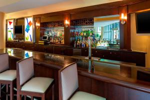 a bar with two chairs and a television at Sheraton Hotel Metairie New Orleans in Metairie