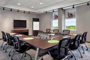 uma sala de conferências com uma grande mesa e cadeiras em Aloft Montreal Airport em Dorval