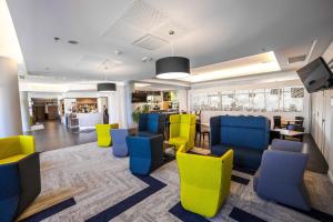 圖盧茲的住宿－萬豪圖盧茲機場度假酒店，一间设有黄色和蓝色椅子的等候室