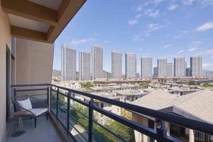 a balcony with a chair and a view of a city at Element Xiamen Tong'an in Xiamen