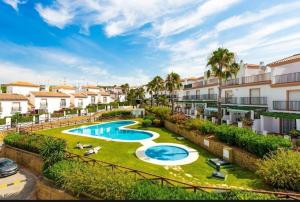 une image d'un complexe d'appartements avec une piscine dans l'établissement Jolie maison à Cabopino Marbella, à Marbella