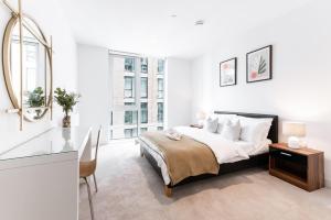 a white bedroom with a bed and a desk at Khayat Homes - The Owelor - Two Bed in London