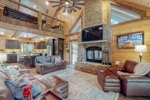 a living room with leather furniture and a fireplace at Tranquil Waters Cabin in Ellijay