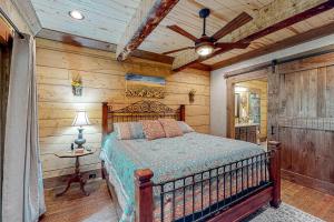 a bedroom with a bed and a ceiling fan at Tranquil Waters Cabin in Ellijay