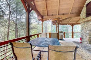 a patio with a table and chairs on a deck at Tranquil Waters Cabin in Ellijay