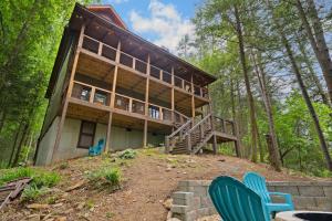 a house on top of a hill with two blue chairs at Tranquil Waters Cabin in Ellijay