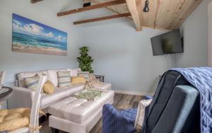 a living room with a couch and a tv at Driftwood - Meredith Lodging in Rockaway Beach