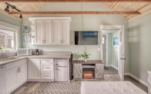 cocina con armarios blancos y chimenea en Beach Bliss - Meredith Lodging, en Rockaway Beach 32 fotos más