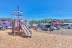 Un parque infantil con un tobogán en un estacionamiento en Beach Bliss - Meredith Lodging, en Rockaway Beach
