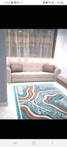 een woonkamer met een bank en een tapijt bij شقة بالاسكندرية سوبر لوكس بالمعمورة الشاطئ in New cairo