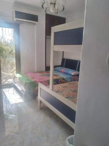 een slaapkamer met een stapelbed in een kamer bij شقة بالاسكندرية سوبر لوكس بالمعمورة الشاطئ in New cairo