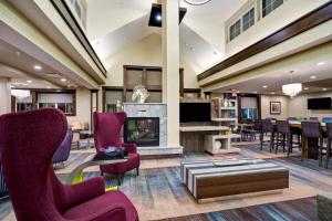 a lobby with chairs and a fireplace and a table at Residence Inn by Marriott Hamilton in Hamilton