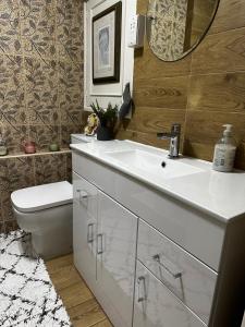 ein Badezimmer mit einem Waschbecken, einem WC und einem Spiegel in der Unterkunft Room in Central London Overview Thames in London