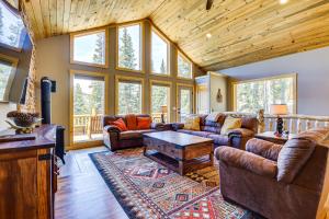 a living room with couches and a table at Family-Friendly Fairplay Cabin with Deck and Mtn Views in Fairplay