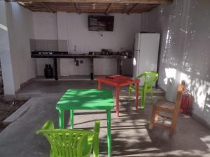 una cocina con mesas y sillas verdes y rojas en 420 Route's Backpackers en Nazca