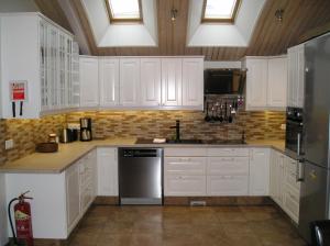 a kitchen with white cabinets and a stove top oven at Three Sisters Apartments in Reykjavík