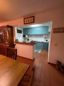 een keuken met blauwe kasten en een houten tafel en een tafel sidx sidx bij Jasmine Beachouse in Lagos