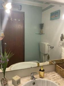 een badkamer met een bad, een wastafel en een spiegel bij Jasmine Beachouse in Lagos