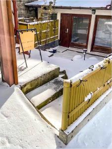 una cerca cubierta de nieve frente a una casa en 星のワルツ　御家堂(Oiedo) en Komoro