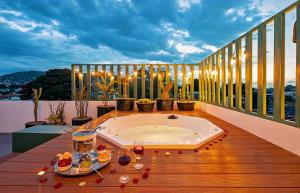 a hot tub on a balcony with wine glasses at HOLT - Villa Noria - La Casa del Barro Verde in Oaxaca City