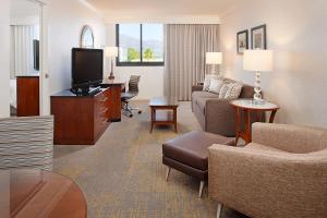 a living room with a couch and a tv in a hotel room at Los Angeles Marriott Burbank Airport in Burbank