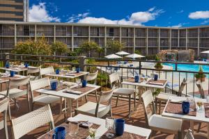 an outdoor restaurant with tables and chairs and a pool at Four Points by Sheraton Little Rock Midtown in Little Rock