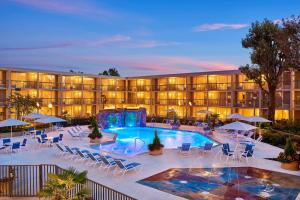 a hotel with a pool and chairs and a resort at Four Points by Sheraton Little Rock Midtown in Little Rock