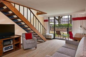 a living room with a television and a staircase at Four Points by Sheraton Little Rock Midtown in Little Rock