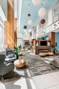 a lobby with couches chairs and a fireplace at Element Calgary Airport in Calgary