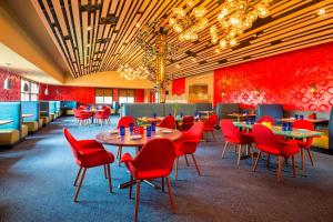 un ristorante con sedie rosse e tavoli in una stanza di Four Points by Sheraton Chicago O'Hare a Schiller Park