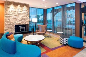 a lobby with blue chairs and a fireplace at Fairfield Inn & Suites by Marriott Houston Pasadena in Pasadena