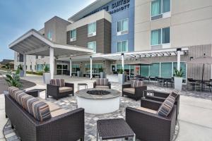 eine Hotelterrasse mit Stühlen und einer Feuerstelle vor einem Gebäude in der Unterkunft TownePlace Suites by Marriott Sarasota/Bradenton West in Bradenton