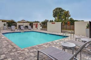 a large swimming pool with chairs and a fence at TownePlace Suites by Marriott Sarasota/Bradenton West in Bradenton
