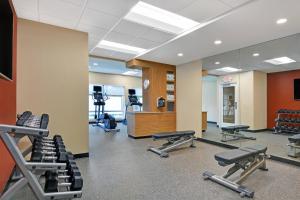 un gimnasio con cintas de correr, equipos de ejercicio y espejo en TownePlace Suites by Marriott Sarasota/Bradenton West, en Bradenton
