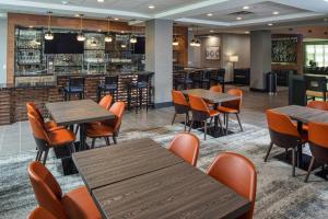 a restaurant with tables and chairs and a bar at Four Points by Sheraton Appleton in Appleton