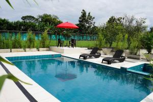 - une piscine avec des chaises et un parasol rouge dans l'établissement Villa Santho, 