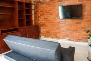a living room with a couch and a tv on a brick wall at Villa Santho 