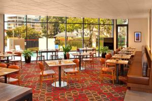 um restaurante com mesas e cadeiras e janelas grandes em Four Points by Sheraton - San Francisco Bay Bridge em Emeryville