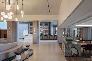 a lobby of a building with tables and chairs at Sheraton Grand Tel Aviv in Tel Aviv +196 photos