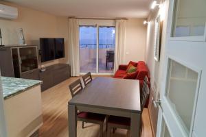 a kitchen and living room with a table and chairs at Àtic Solé in Les Cases d'Alcanar