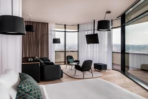 a bedroom with a bed and a living room at Courtyard by Marriott Brno in Brno