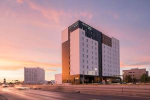 a tall building with a sign on top of it at Courtyard by Marriott Ciudad Juarez in Ciudad Juárez