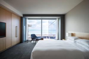 a hotel room with a bed and a chair and a window at Marriott Marquis Chicago in Chicago