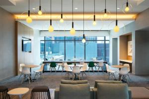 uma sala de jantar com mesas, cadeiras e janelas em Marriott Marquis Chicago em Chicago