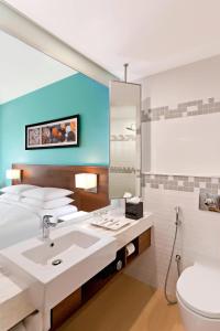 a bathroom with a sink and a toilet and a mirror at Fairfield by Marriott Coimbatore in Coimbatore