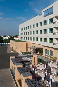 un hotel con mesas y sillas frente a un edificio en Fairfield by Marriott Coimbatore, en Coimbatore