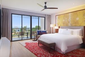 a bedroom with a large white bed and a balcony at The Westin Desaru Coast Resort in Desaru