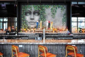 a bar with a large mural of a woman at Le Meridien Essex Chicago in Chicago